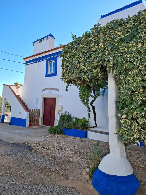 a blue and white building with a tree in front of it at Casa Azenha das Freiras in Borba