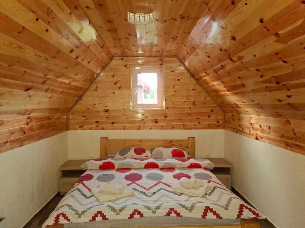 een slaapkamer met een bed in een houten hut bij Cottage Martina in Žabljak