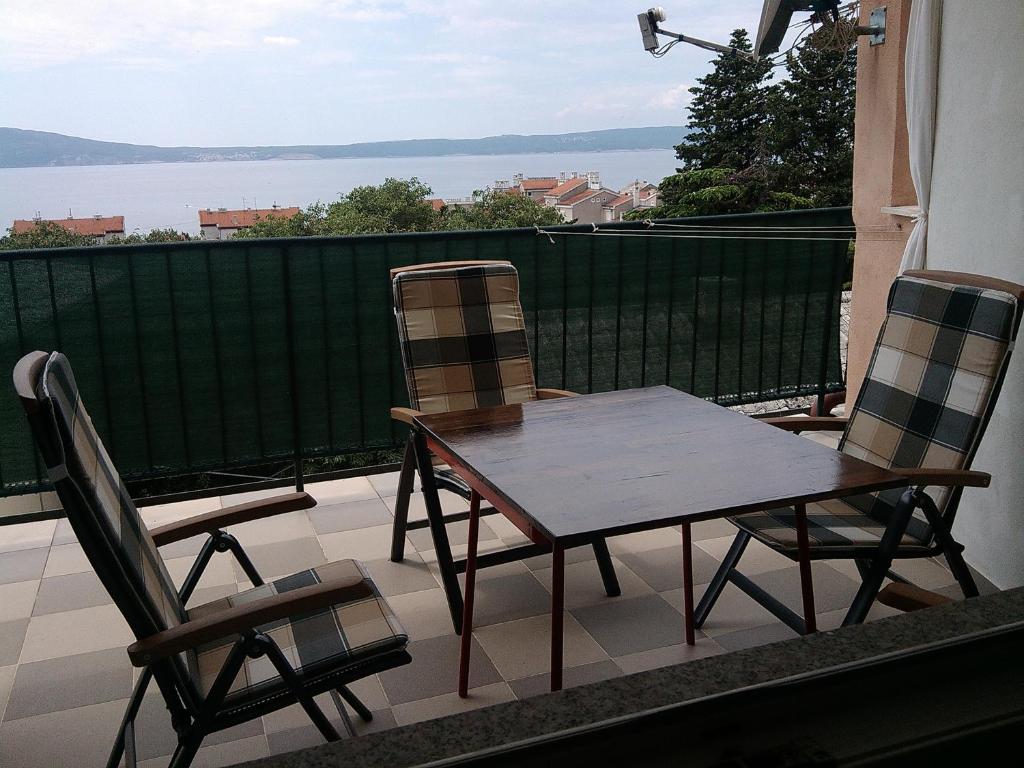 una mesa y sillas en un balcón con vistas al agua en Apartment Dada, en Novi Vinodolski