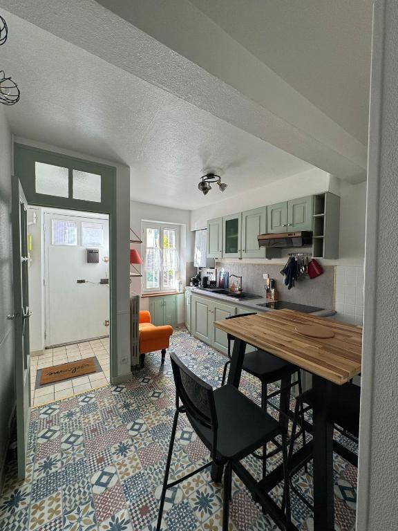 une cuisine avec une table et des chaises dans une pièce dans l'établissement La Petite Fuxéenne, à Foix