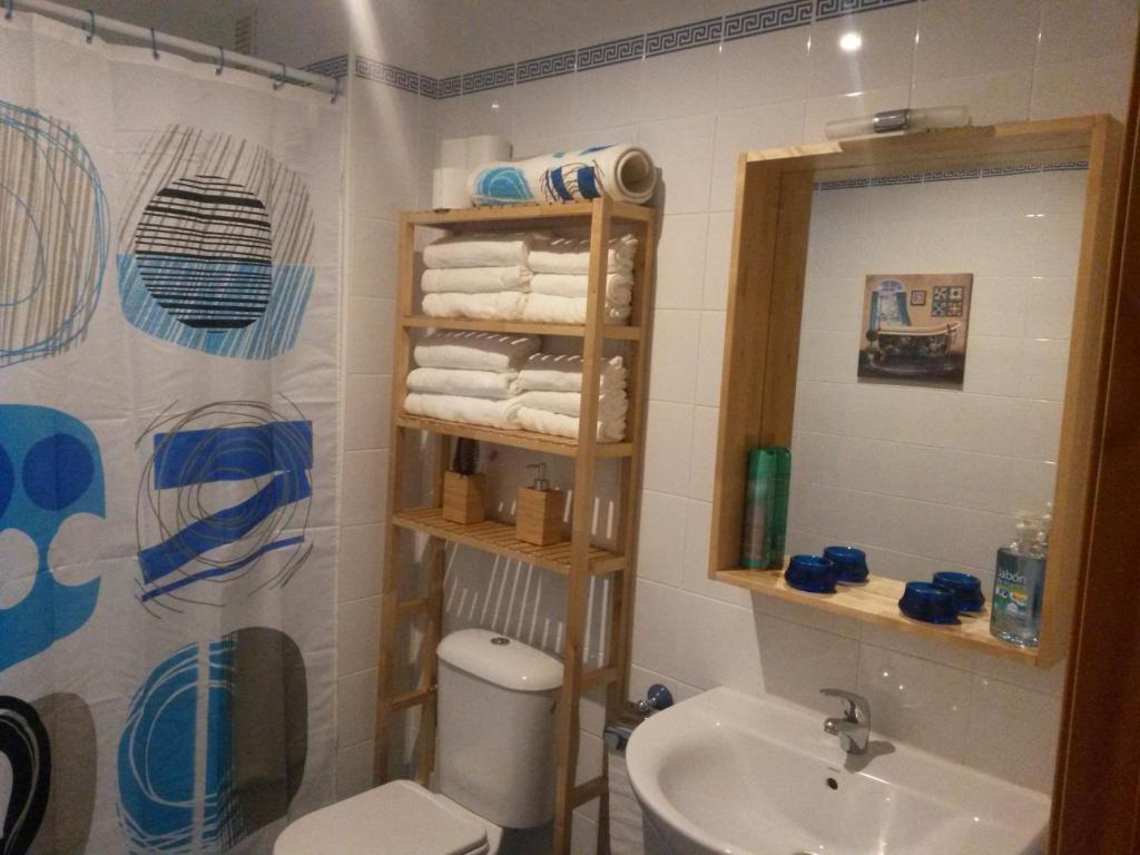łazienka z umywalką, toaletą i lustrem w obiekcie Apartamento Oropendola 9 w mieście El Puerto de Santa María