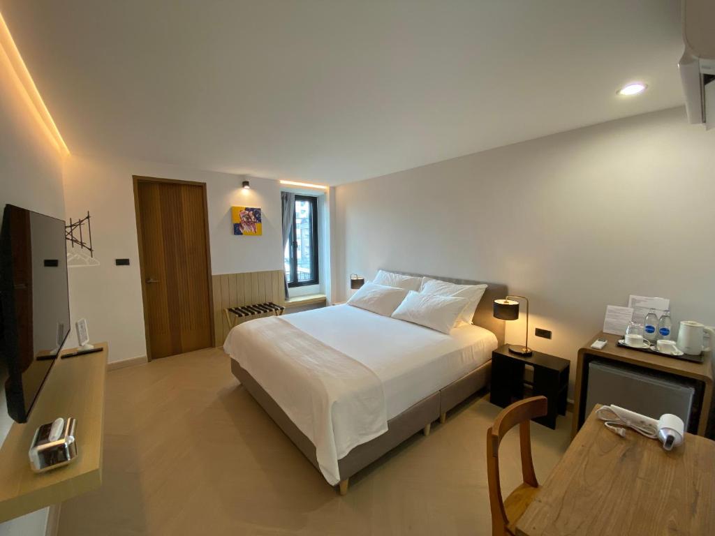 a bedroom with a white bed and a wooden table at The Celestrail - Check-In by Appointment Only Non-Hotel Private Apartment Onnut BTS in Amphoe Phra Khanong