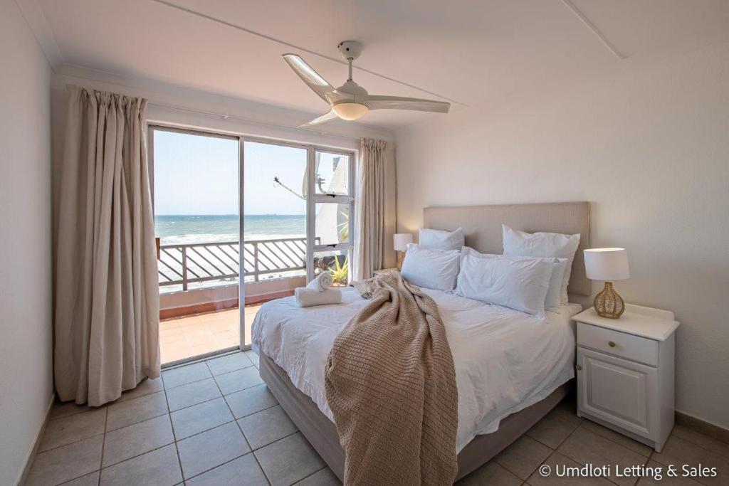 a bedroom with a bed with a view of the ocean at 38 Isikhulu in Umdloti