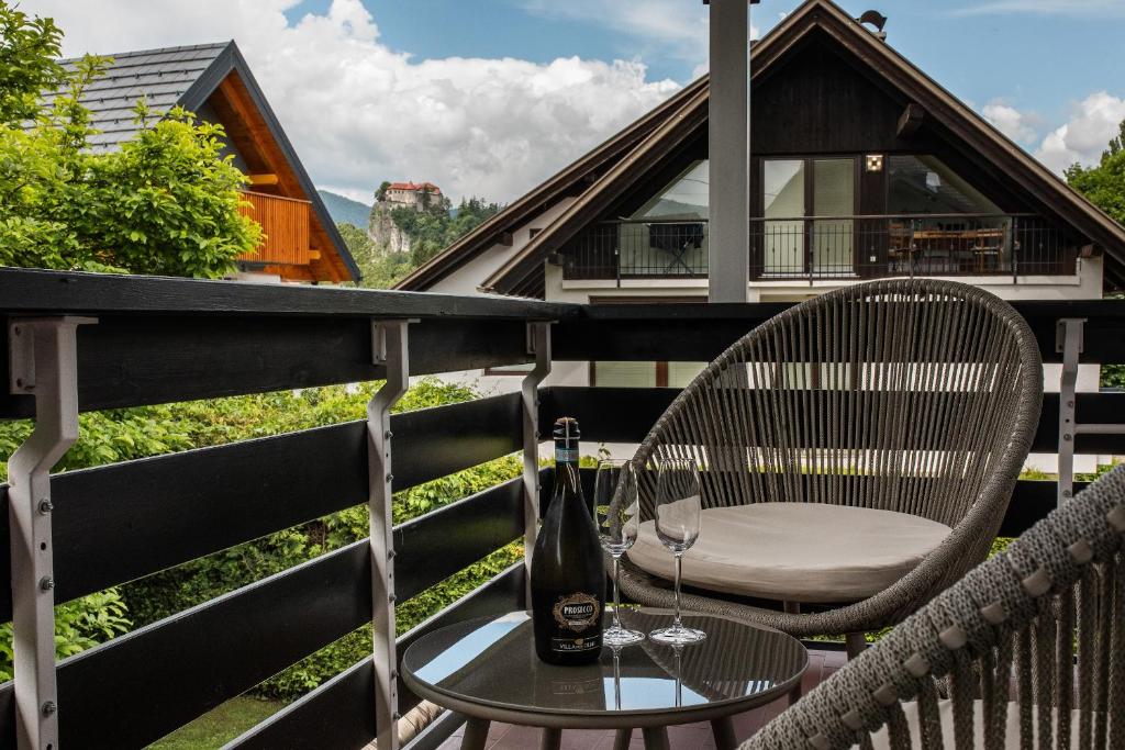 - Balcón con mesa y sillas y botella de vino en Apartments Villa AnnaMaria, en Bled