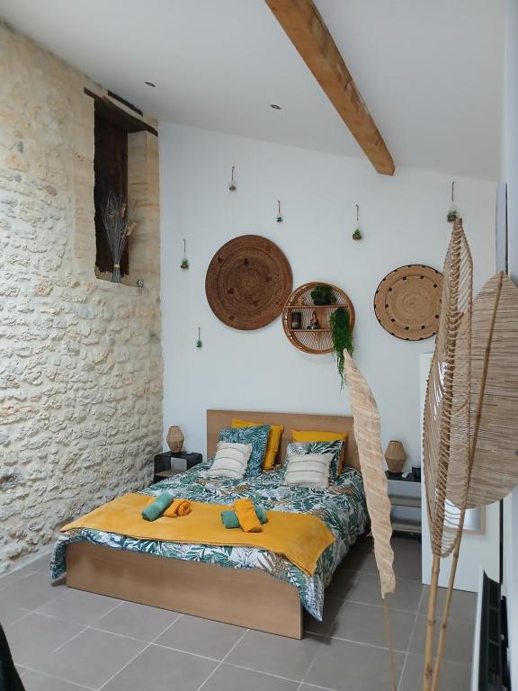 a bedroom with a bed and a stone wall at Le Cosy Cabarieu in Saint-André-de-Cubzac