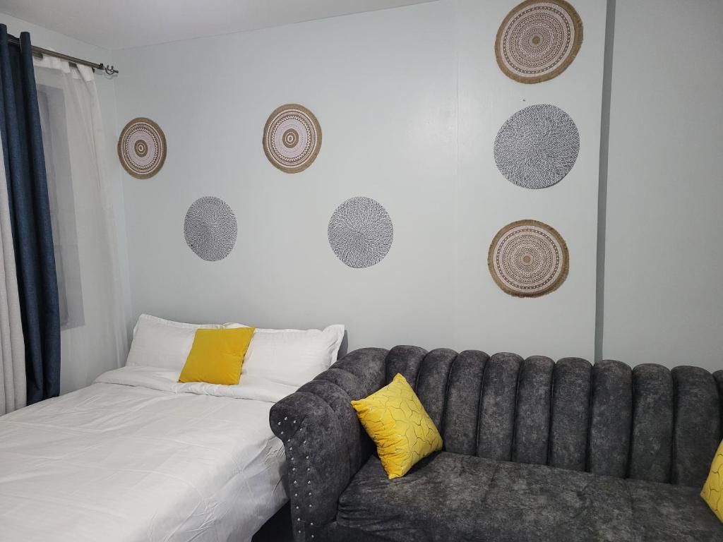 a bedroom with a couch next to a bed at VIVI GRAY ,Muthiga, Waiyaki Way in Nairobi