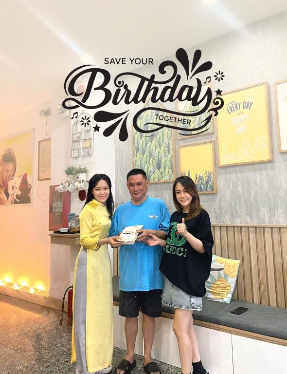 a man and two women standing in front of a store at Happy Day Riverside Hotel & Spa Danang by Haviland in Danang