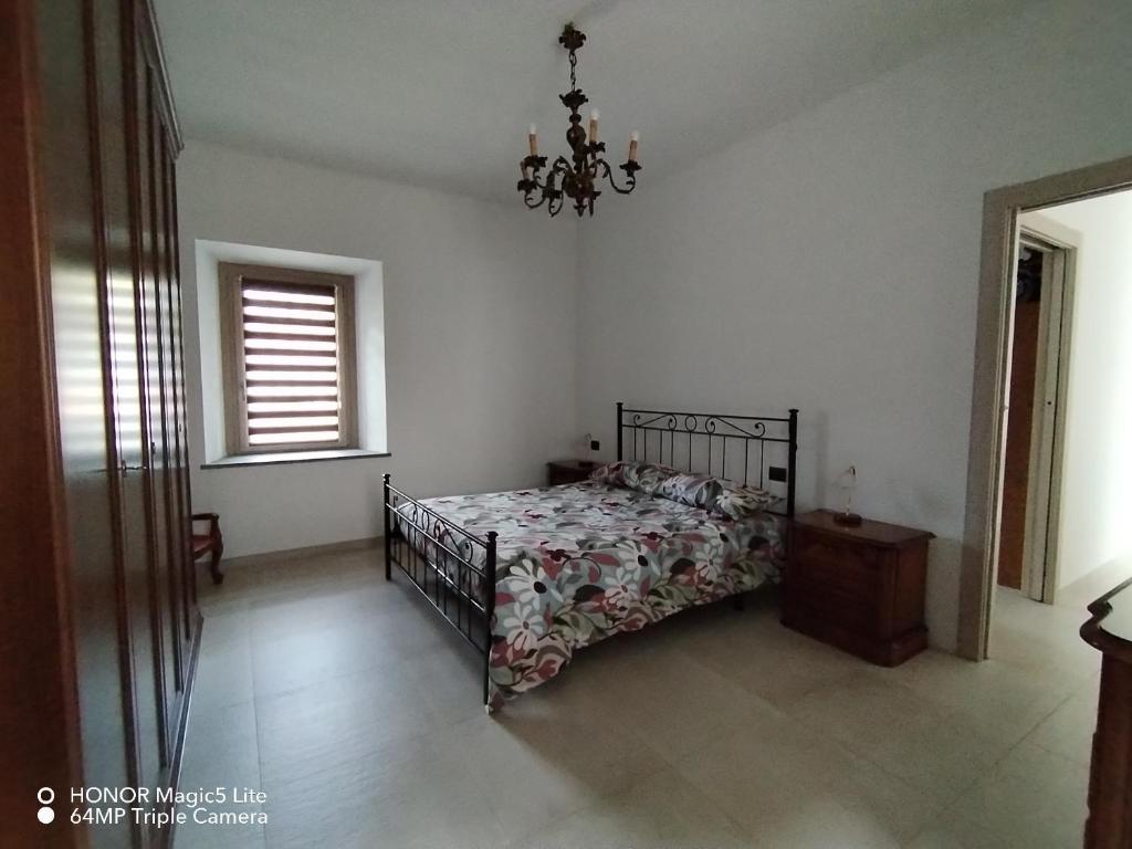 a bedroom with a bed and a chandelier at La Rocchetta - Ai piedi del Parco Naturale in Cavour