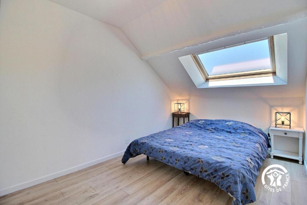 une chambre avec un lit et une lucarne dans l'établissement Ty drenek, à Arradon