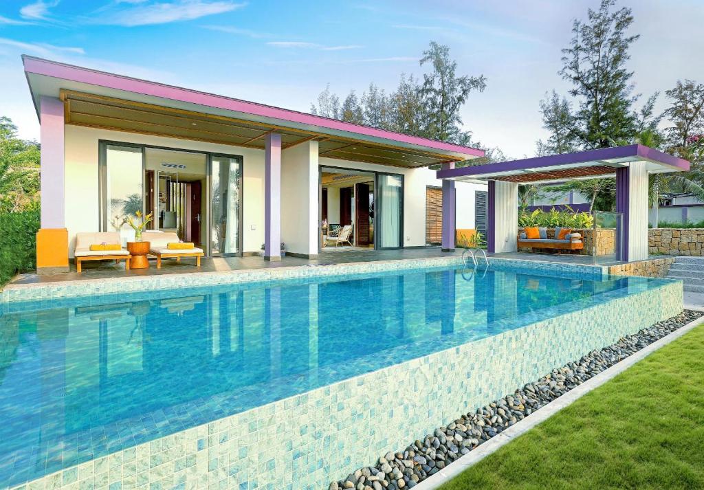 a swimming pool in front of a house at TTC Van Phong Bay Resort - Himalaya Sauna & Steam Retreat Included in Ninh Hòa