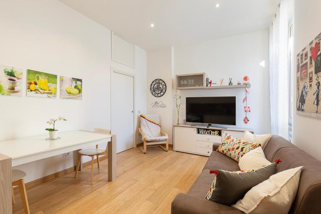 a white living room with a couch and a table at Nice Flat Milan 50m Station! in Milan