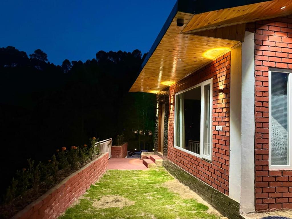 a brick house with lights on the side of it at Kasauli Pine Hill Cottages I Kasauli in Kasauli