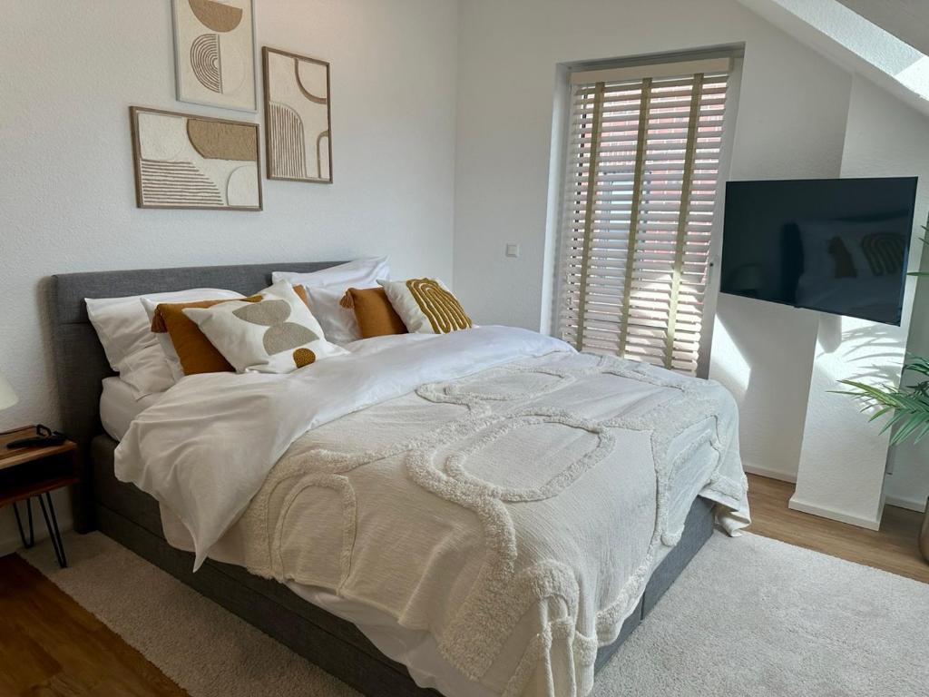 a bedroom with a large bed with white blankets and pillows at Guestroom Meerbusch in Meerbusch