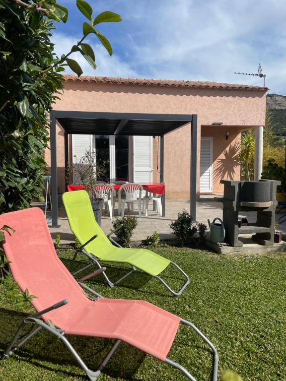 due sedie da giardino e un barbecue in cortile di Charmante Maisonnette t2bis plaine de Calenzana a Calenzana