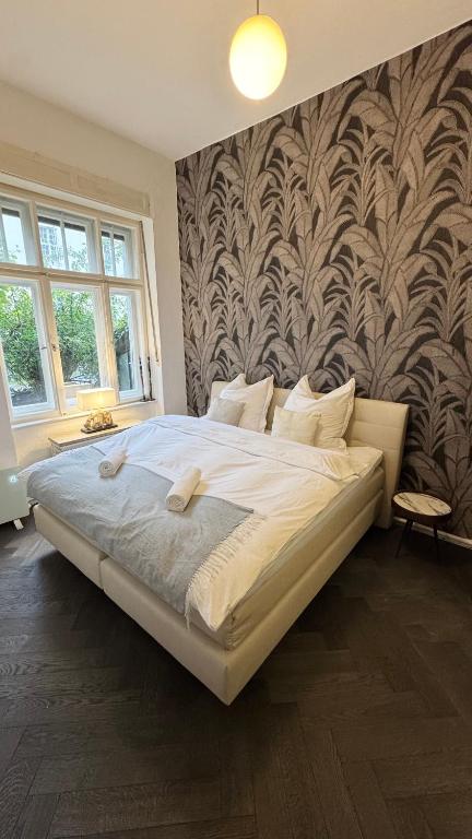 a large bed in a bedroom with a wall at Exklusive Wohnung im Herzen Münchens in Munich