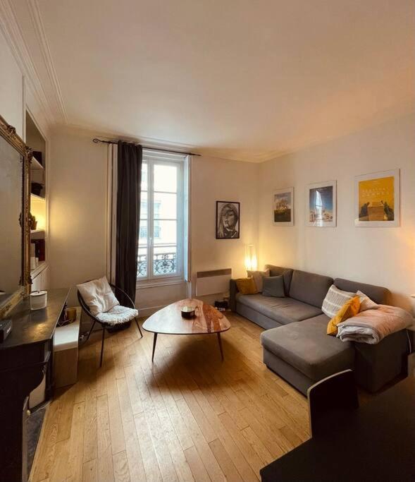 un salon avec un canapé et une table dans l'établissement Paris 9e bel appartement de 40m2, à Paris