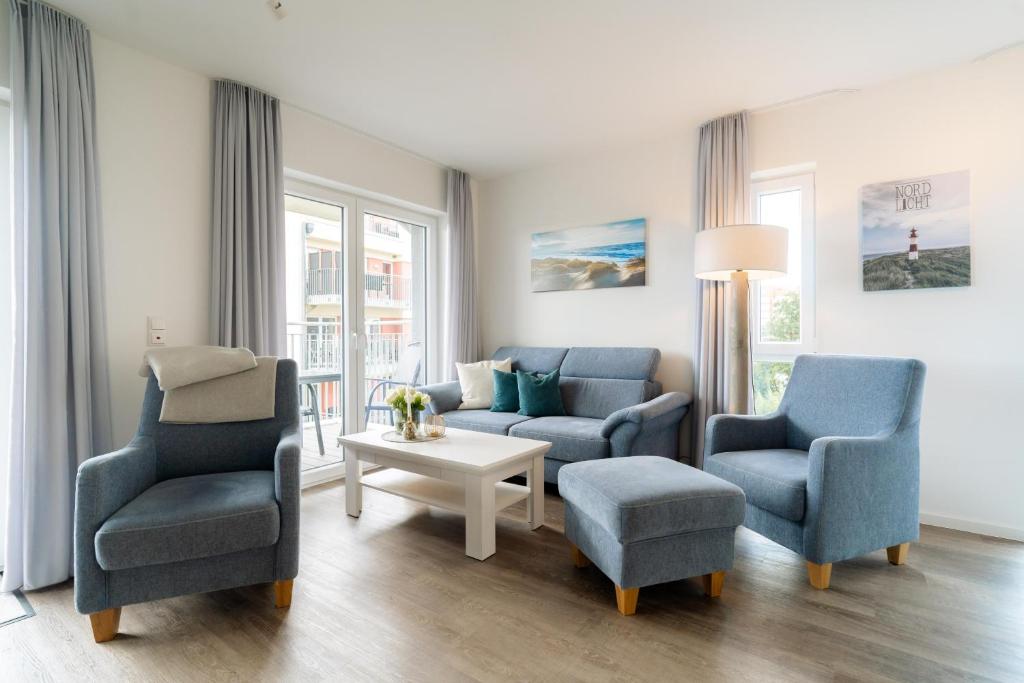 a living room with two chairs and a couch and a table at Seebreeze 50 2 N in Wangerland