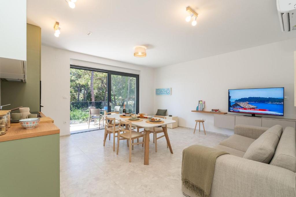 a living room with a couch and a table with chairs at Apartments Irena in Cavtat