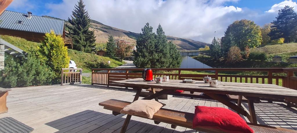 - une table de pique-nique en bois sur une terrasse en bois dans l'établissement CHALET COOP - A - 10 pers, à Le Freney-dʼOisans