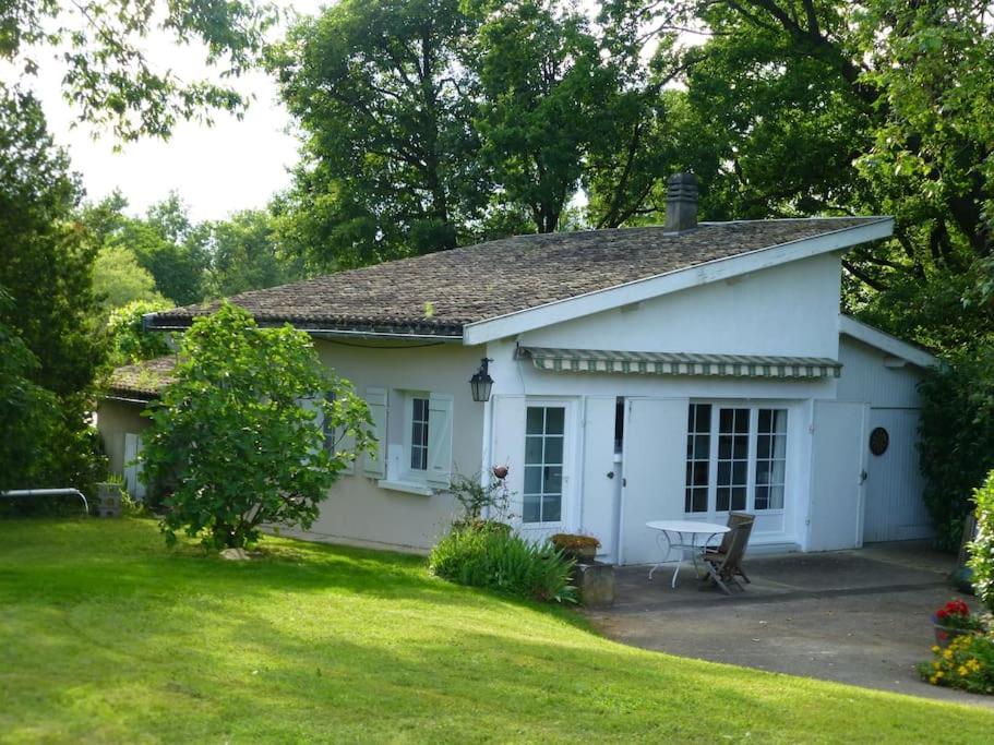 una casa blanca con una mesa de picnic en un patio en La Plumassière, en Saint-Genis-Laval