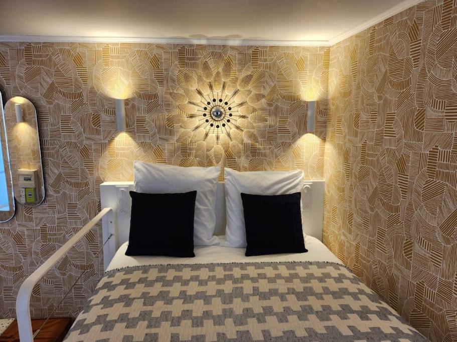 - une chambre avec un lit blanc et un mur à motifs floraux dans l'établissement Cocon déco quartier Antiquaires, à Dijon