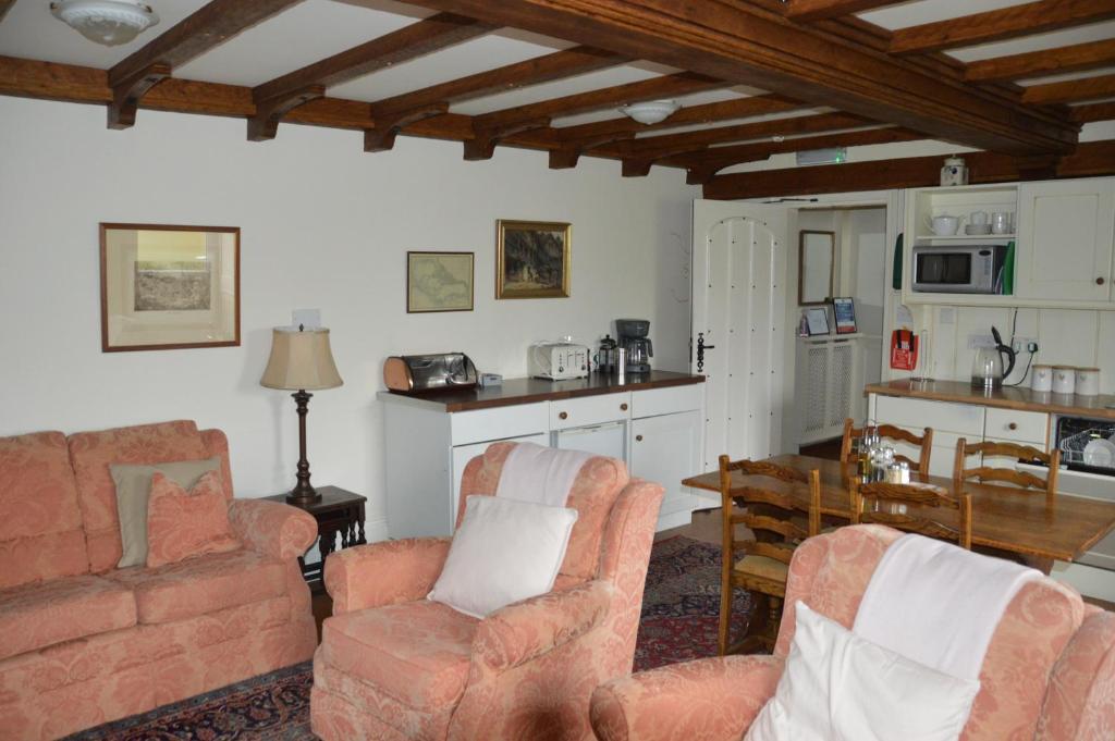 a living room with two chairs and a table at Middlehead Cottages in Pickering