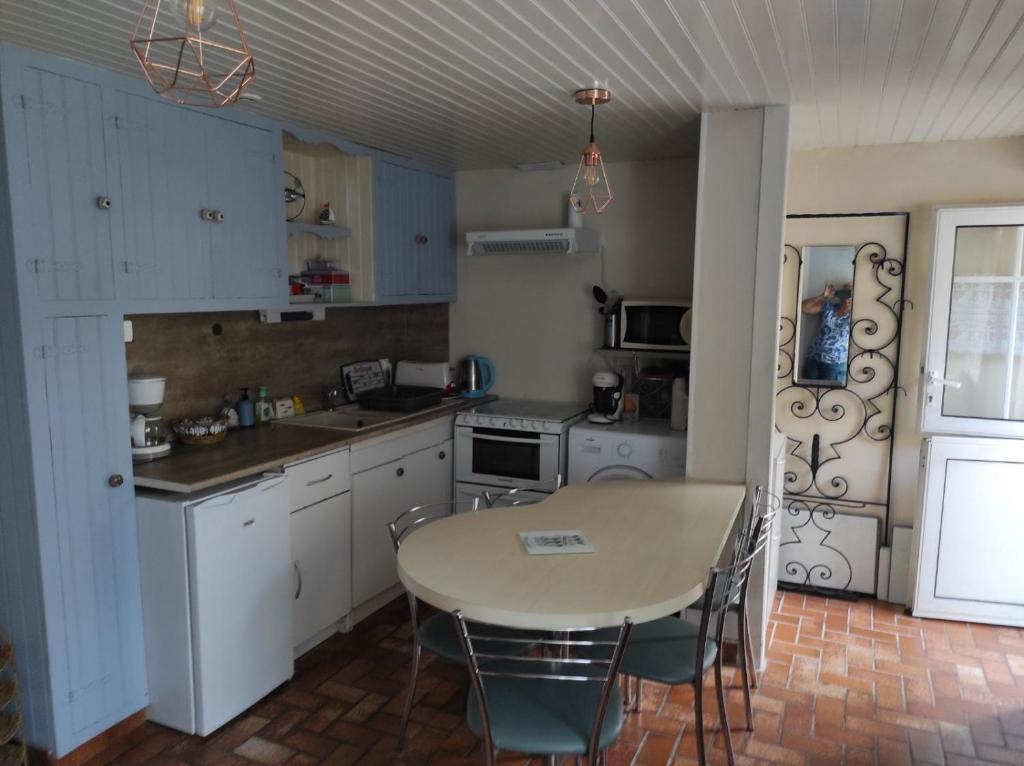 eine Küche mit einem Tisch und einem Tisch und Stühlen in der Unterkunft ty anna in Le Palais