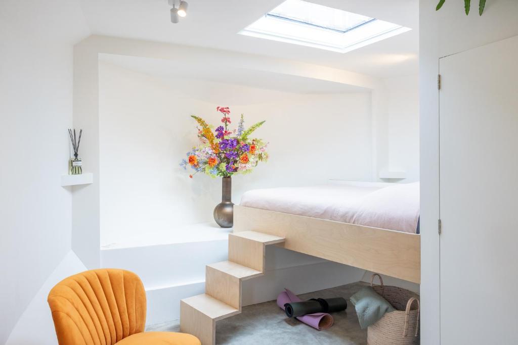 a bedroom with a bed and a bathtub and a chair at Boat suite - A Unique Houseboat Stay in Amsterdam in Amsterdam