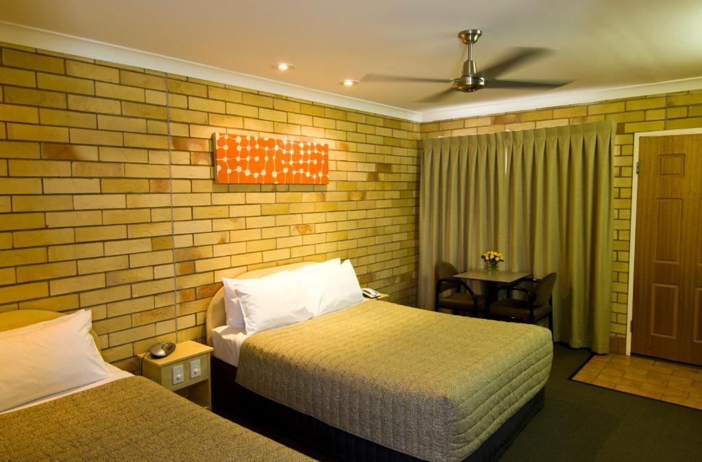 a hotel room with two beds and a table at Starlight Motor Inn in Roma