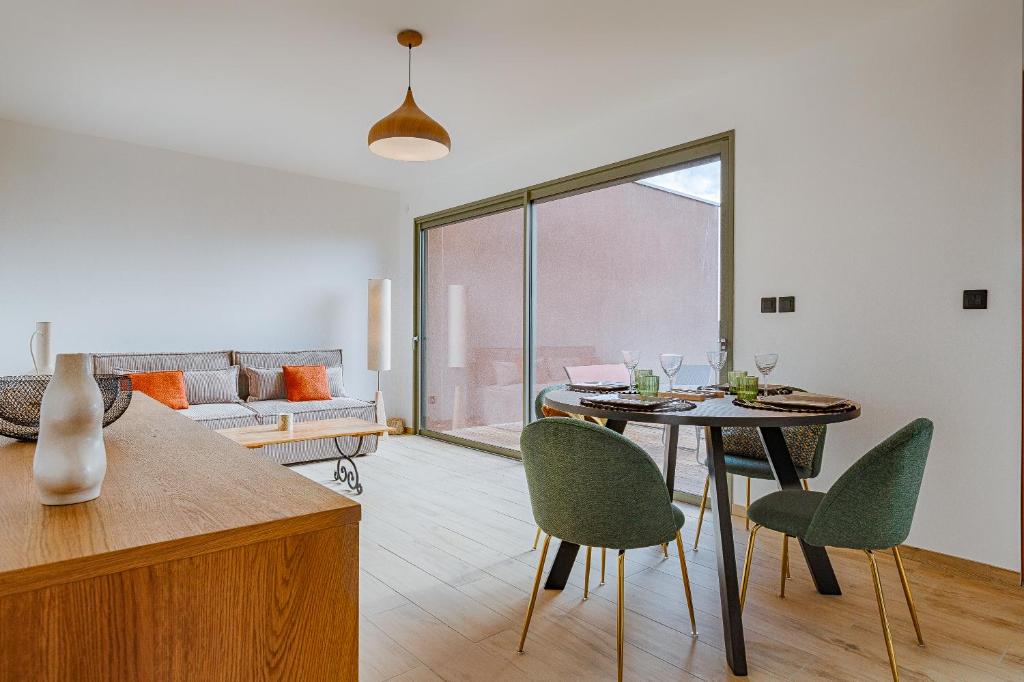 - un salon avec une table et des chaises vertes dans l'établissement Casa Zen, à Vernosc-lès-Annonay