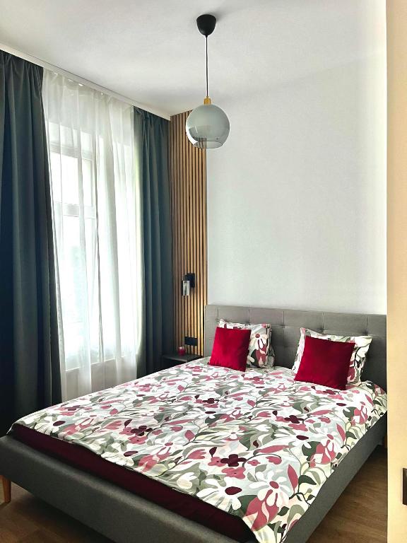 a bedroom with a large bed with red pillows at CHERRY apartment in Riga