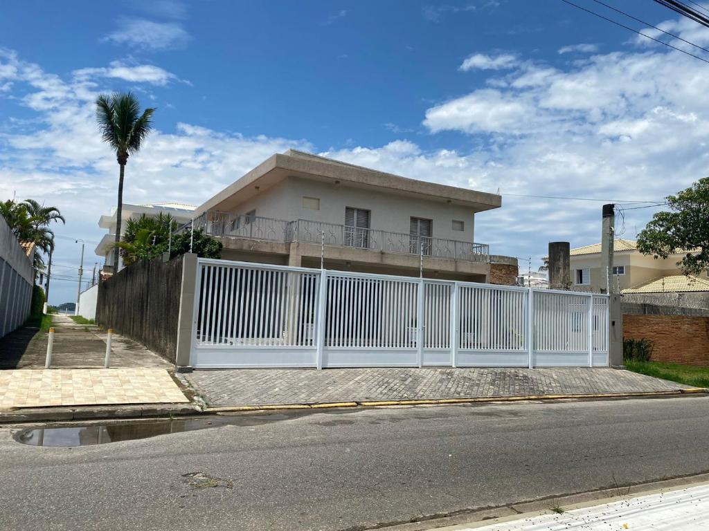 a white fence in front of a house at Casa 50m da praia - Enseada/Guarujá in Guarujá