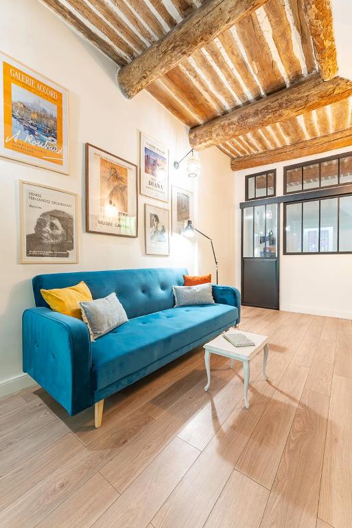 un salon avec un canapé bleu et une table dans l'établissement T1 pop tout neuf au Panier, à Marseille