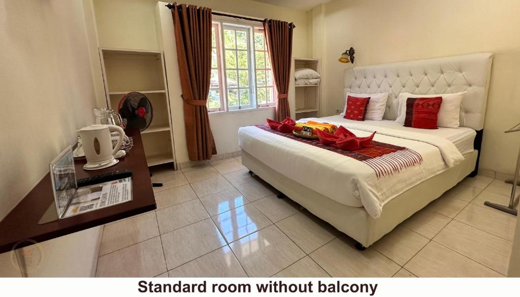 a bedroom with a large bed with aamed room without jealousy at Zoé’s Paradise Waterfront Hotel in Tuktuk Siadong
