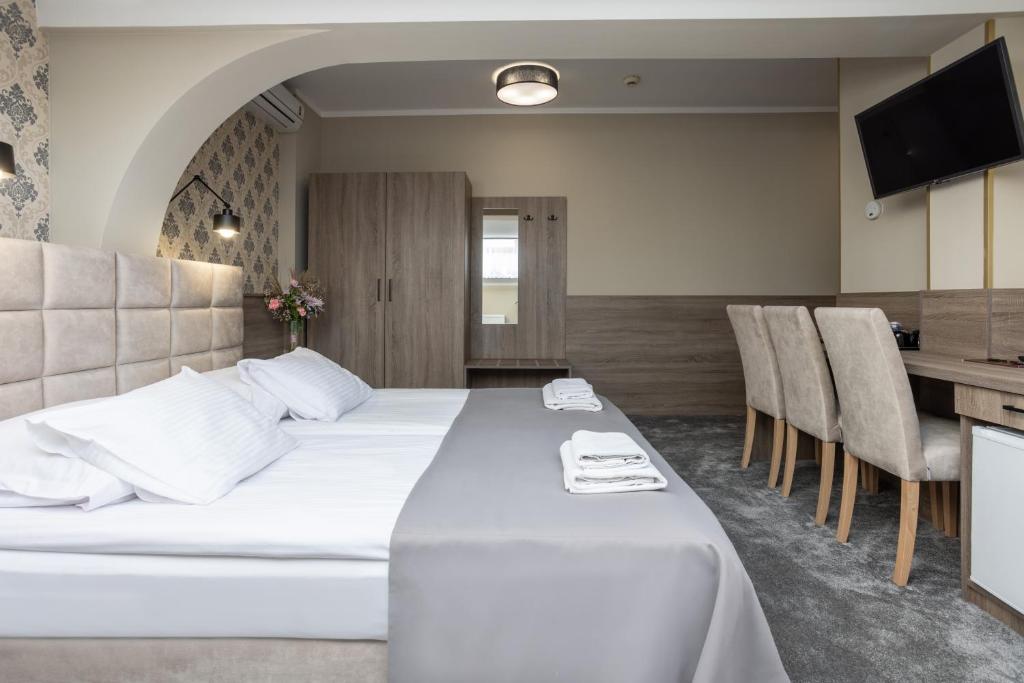 a hotel room with a bed and a table and chairs at Hotel Maksymilian in Krakow