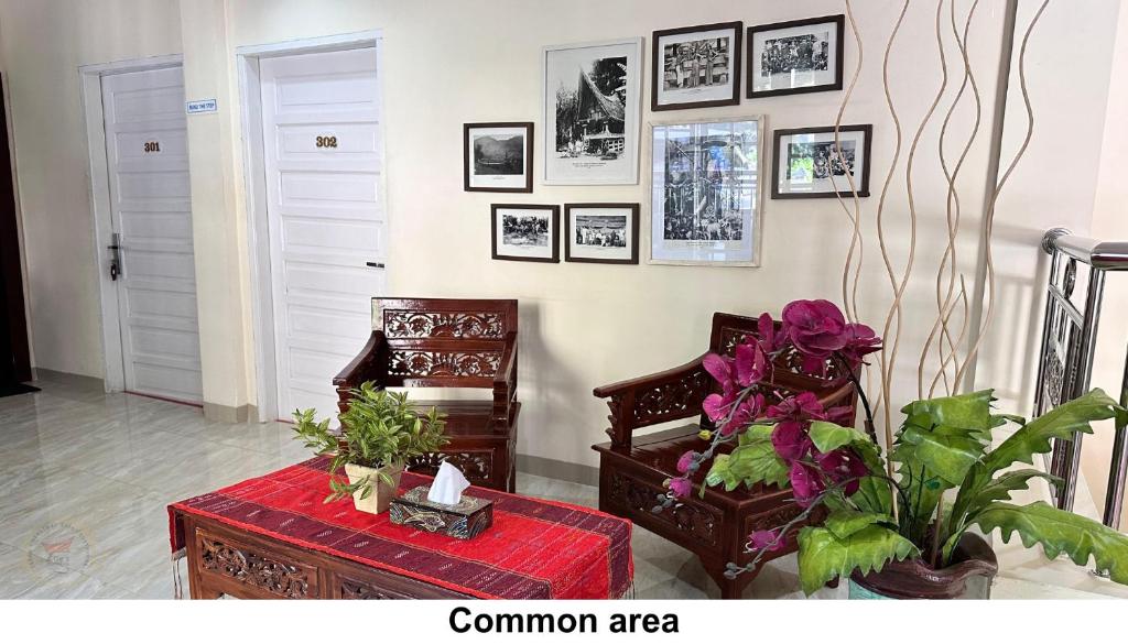 a room with a table and a chair and pictures on the wall at Zoé’s Paradise Waterfront Hotel in Tuktuk Siadong