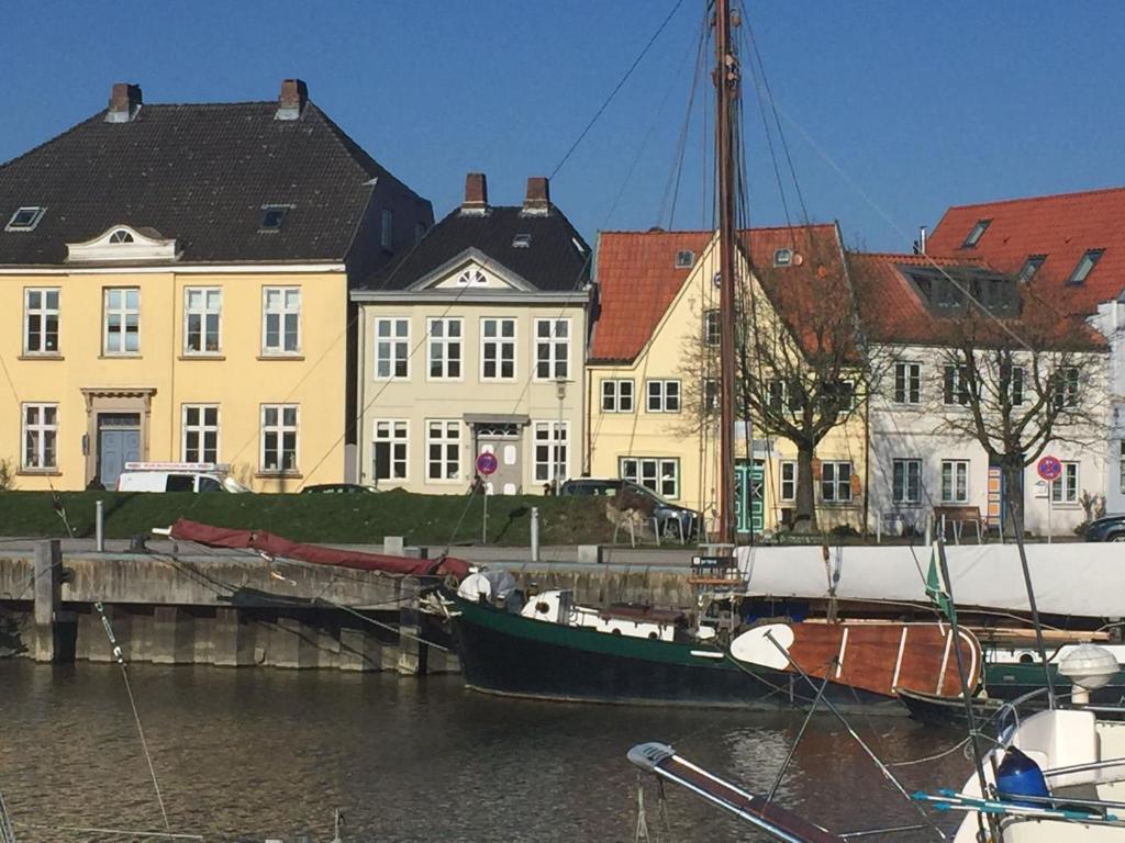 a boat docked in the water in front of buildings at Am Hafen 13 in Glückstadt
