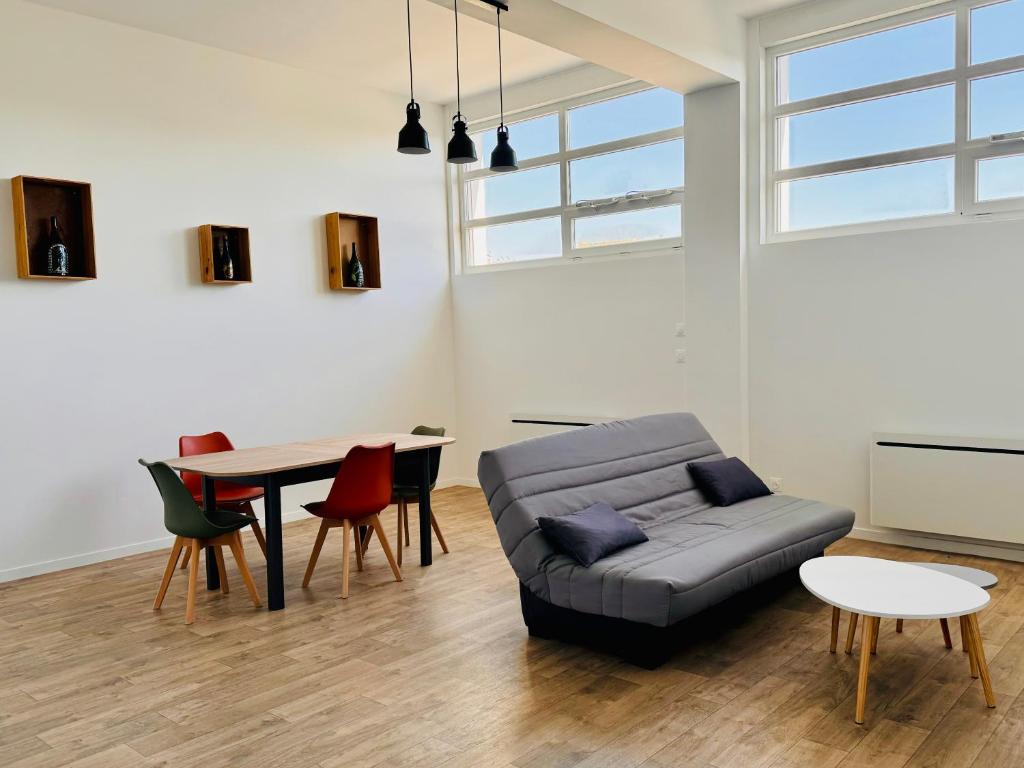 a living room with a couch and a table at Appartement Champagne in Châlons-en-Champagne