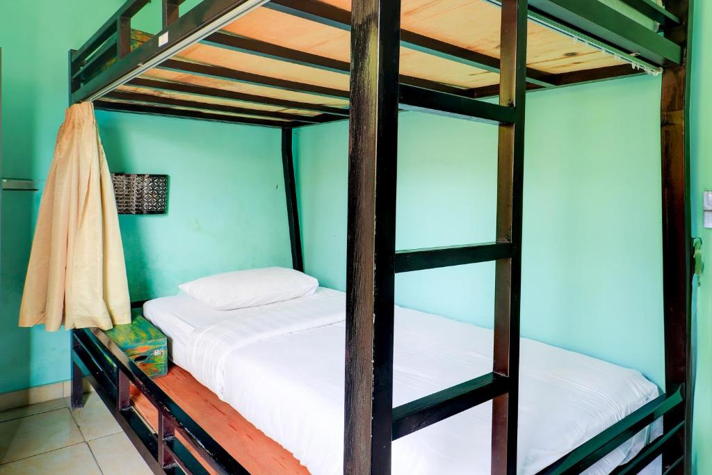 Postel nebo postele na pokoji v ubytování Hotel O Pondok Tulasi Hostel Near Monkey Forest