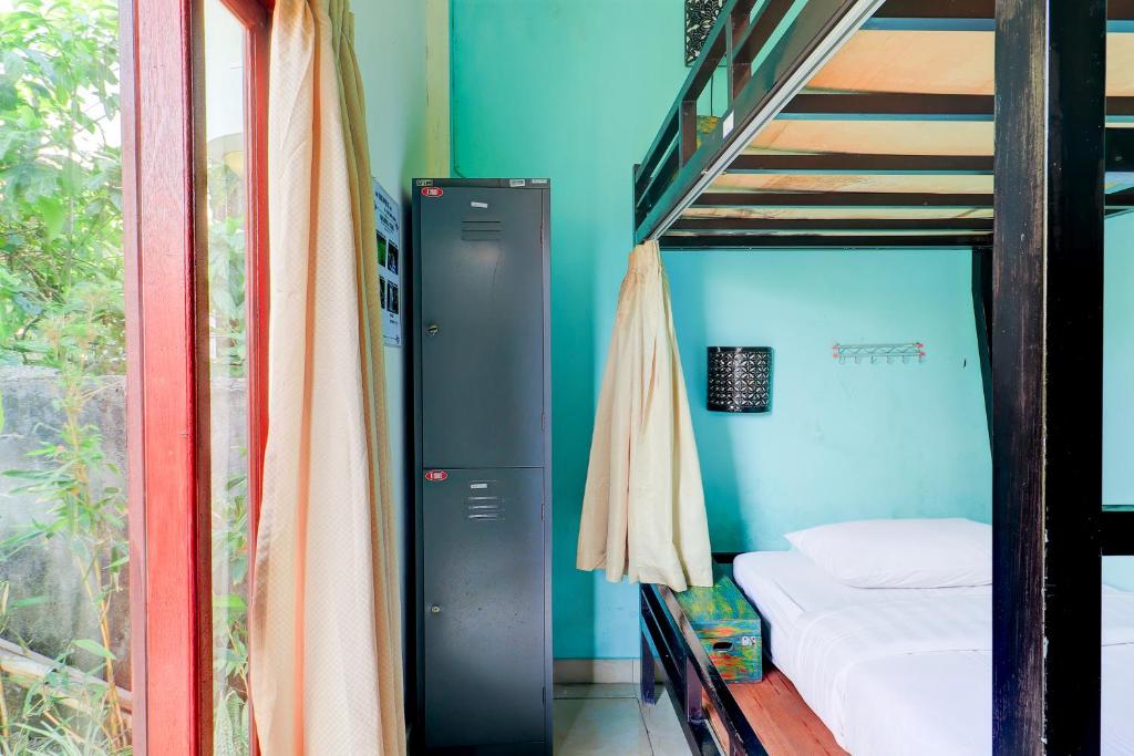 Postel nebo postele na pokoji v ubytování Hotel O Pondok Tulasi Hostel Near Monkey Forest
