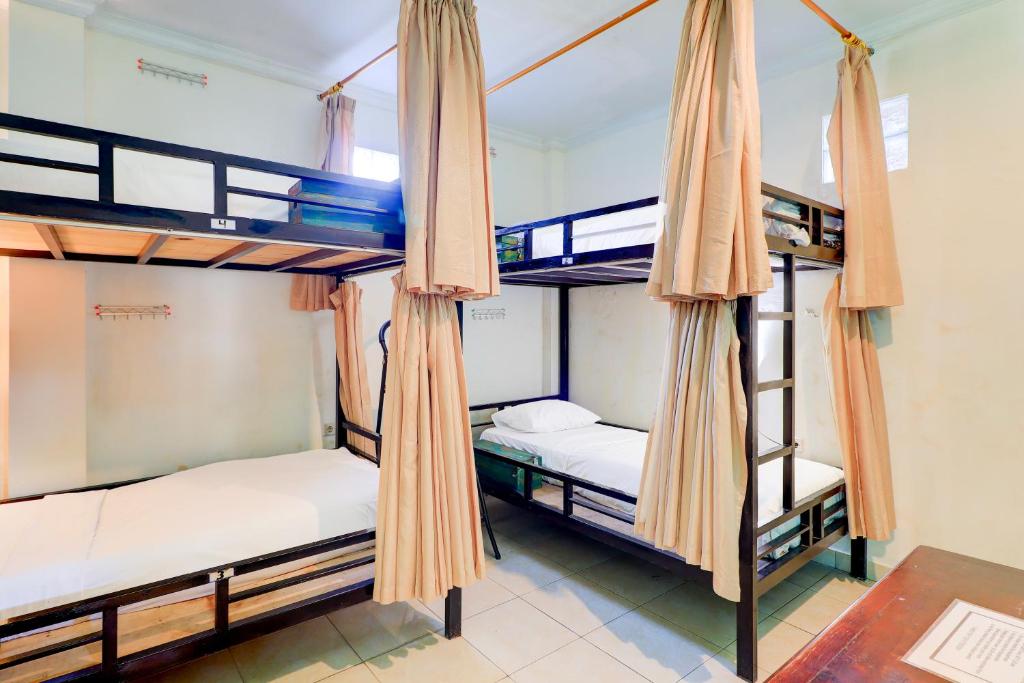 Postel nebo postele na pokoji v ubytování Hotel O Pondok Tulasi Hostel Near Monkey Forest