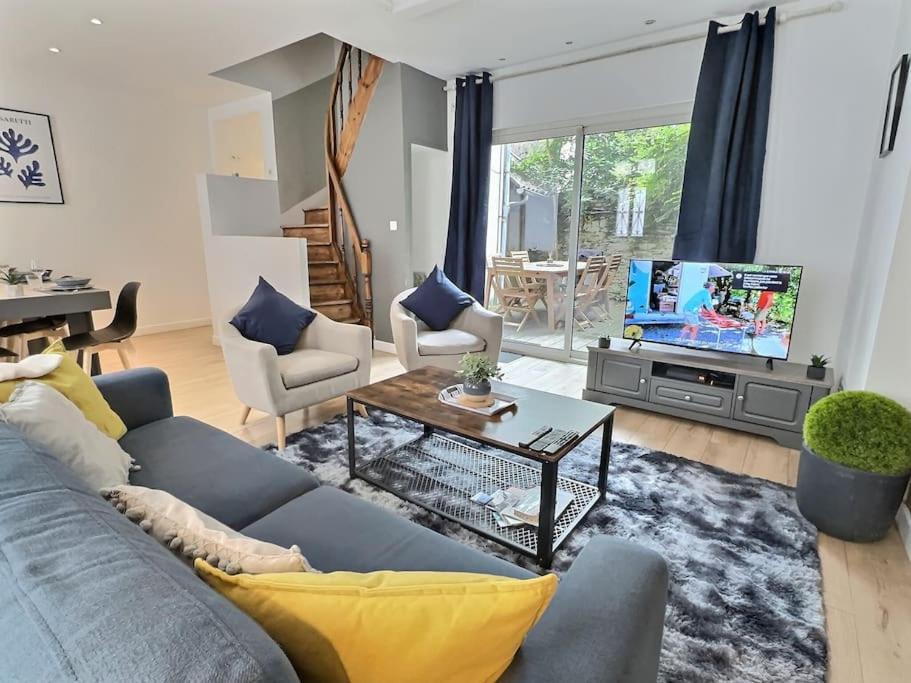 un salon avec un canapé bleu et une télévision dans l'établissement Confort et convivialité au rendez-vous, Centre Angers-Musset, à Angers