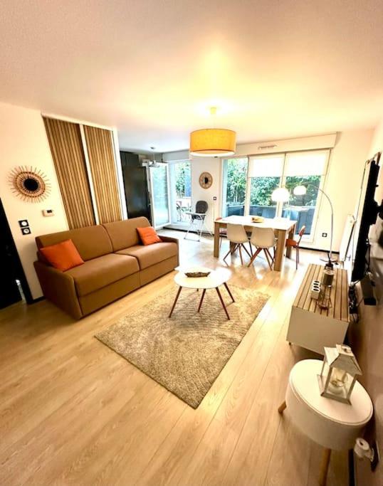 un salon avec un canapé et une table dans l'établissement Cosy flat with garden, close to Paris and metro station, à Romainville