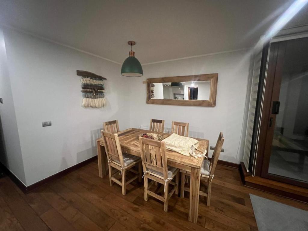a dining room with a wooden table and chairs at Lo Mejor de Pucón II in Pucón