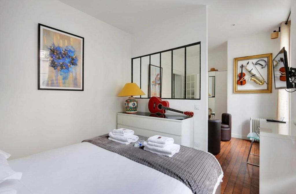 une chambre avec un lit avec deux serviettes dessus dans l'établissement Magnifique 2 pièces, clair neuf, à Paris