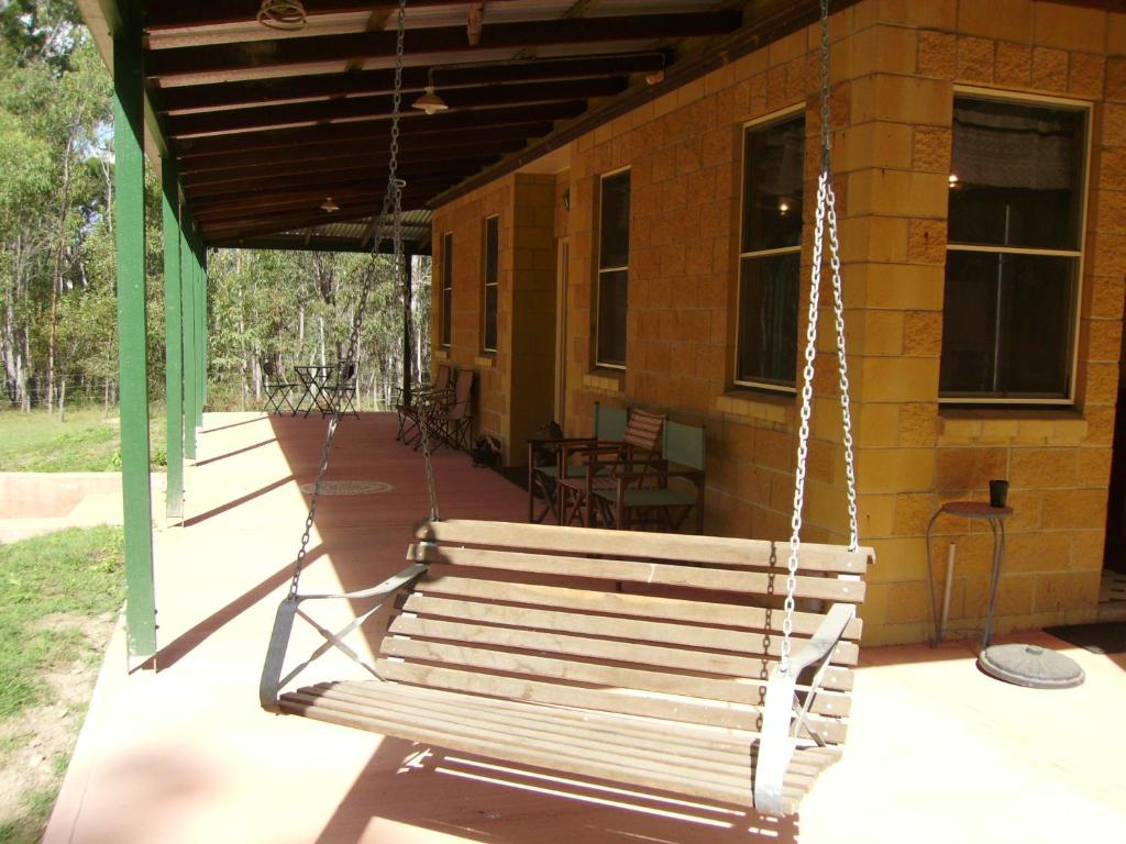 eine schwingende Bank auf einer Veranda eines Hauses in der Unterkunft Back to the Bush in Aramara