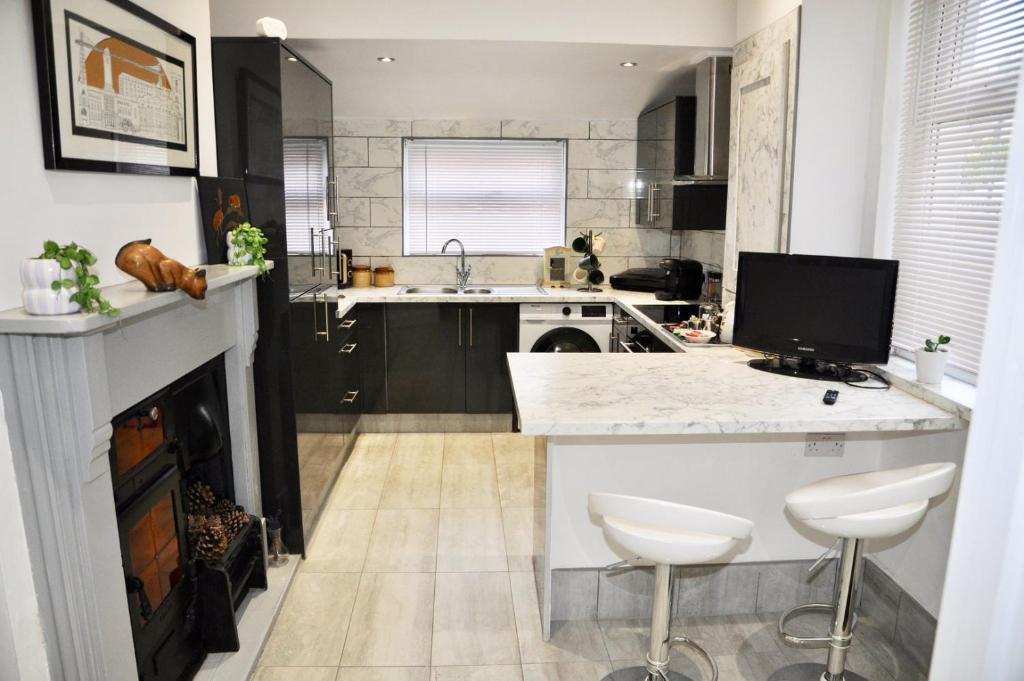 a kitchen with a counter and a fireplace at The Great Escape by Tŷ SA in Newport