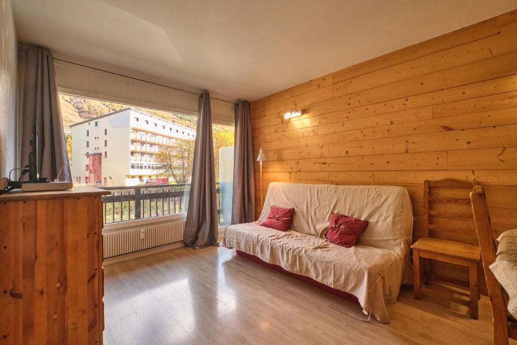 un salon avec un canapé et une grande fenêtre dans l'établissement Olympe - Les 2 Alpes, à Les Deux Alpes