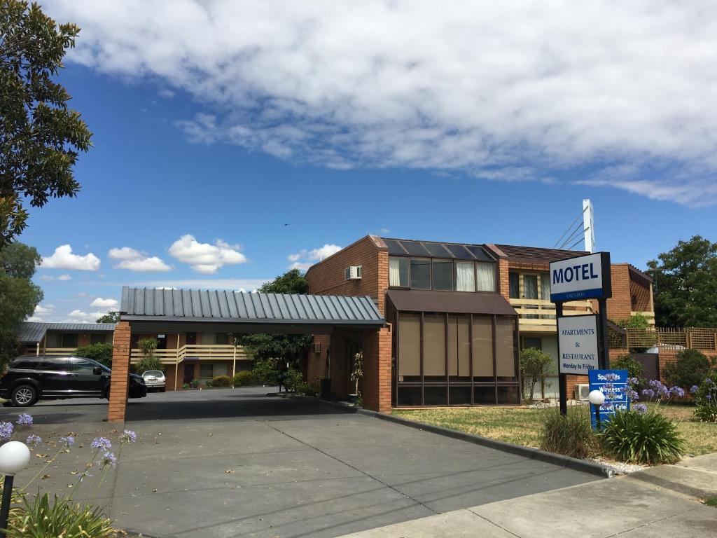 una señal de motel frente a un edificio en Essendon Motel en Melbourne