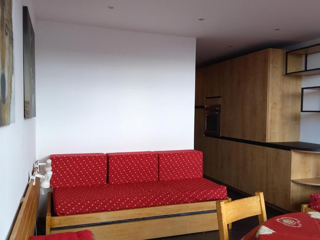 a red couch in a room with a kitchen at Studio confortable pour 4 personnes à Arc 1600, proche des pistes - FR-1-411-396 in Arc 1600